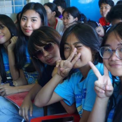 Students in class making peace signs